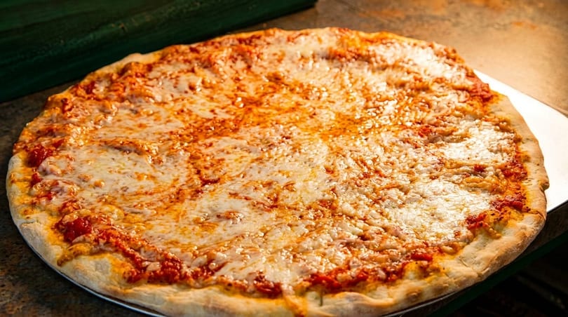 A large, freshly baked cheese pizza with a golden crust and melted mozzarella cheese.