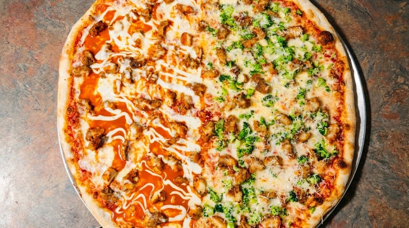 Half buffalo chicken pizza with ranch drizzle, half chicken and broccoli pizza with white sauce.